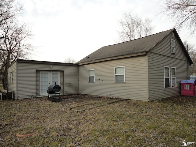 back of property with french doors and a yard