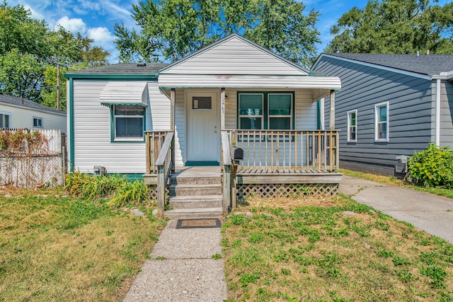 bungalow with covered porch and a front yard