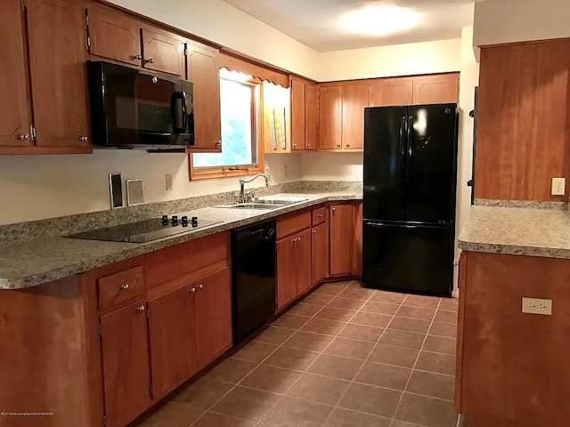 kitchen featuring sink, dark tile patterned floors, and black appliances