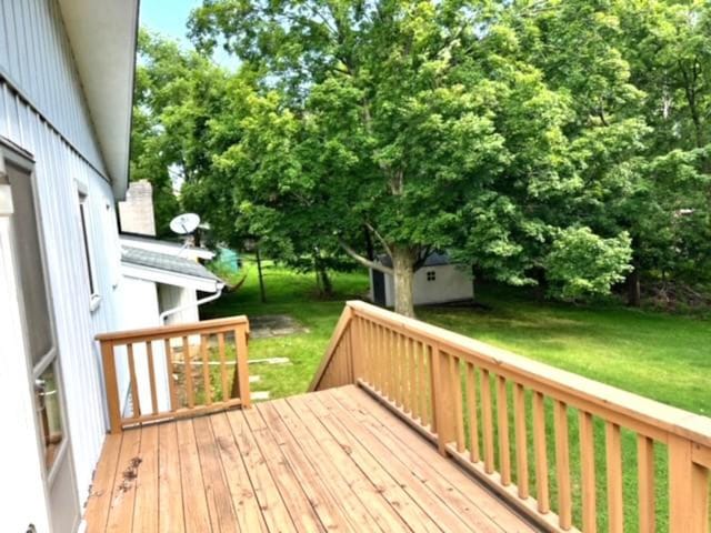 wooden terrace with a shed and a yard