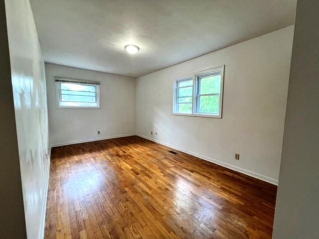 unfurnished room with dark hardwood / wood-style flooring