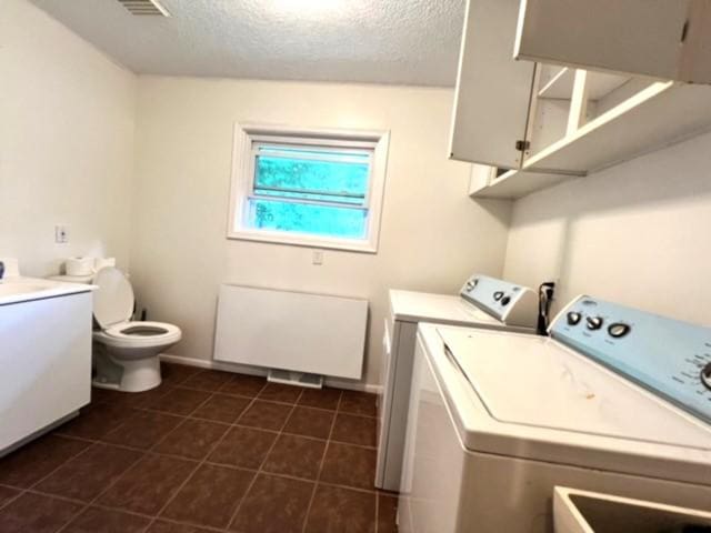 clothes washing area with washer and dryer and a textured ceiling