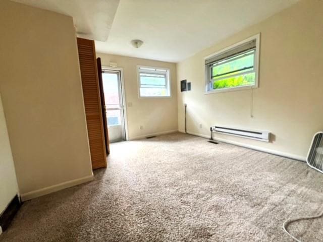 empty room with carpet floors and a baseboard radiator