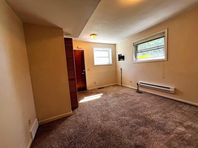 unfurnished room featuring carpet and a baseboard heating unit