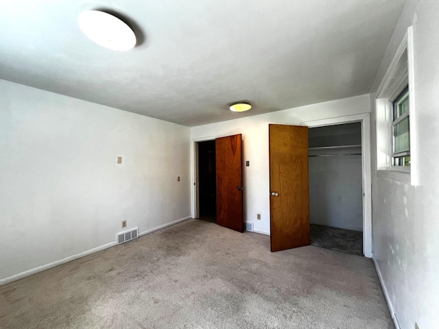 unfurnished bedroom with light carpet and a closet