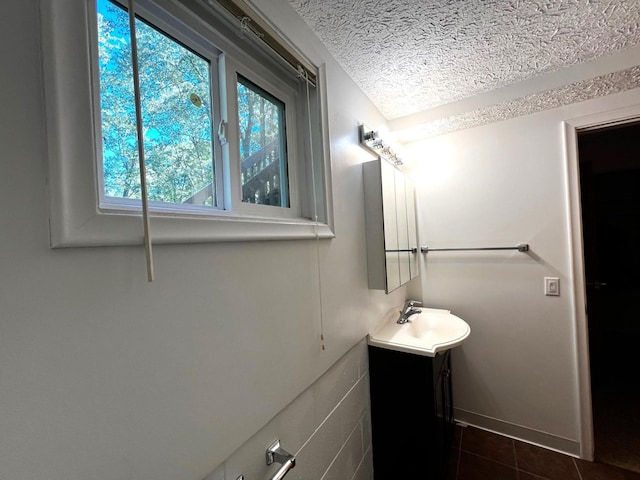 bathroom with tile patterned floors, vanity, and a textured ceiling