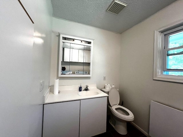 bathroom featuring tile patterned floors, vanity, toilet, and a textured ceiling