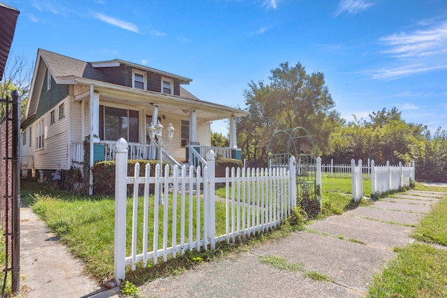 bungalow-style house featuring covered porch and a front lawn