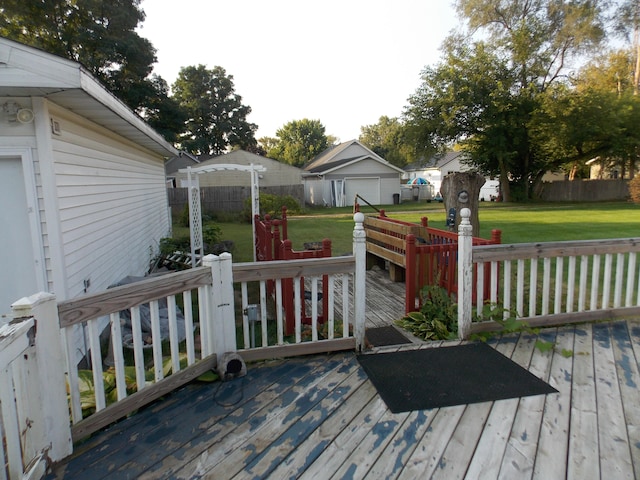 deck featuring a yard, a pergola, and a storage unit