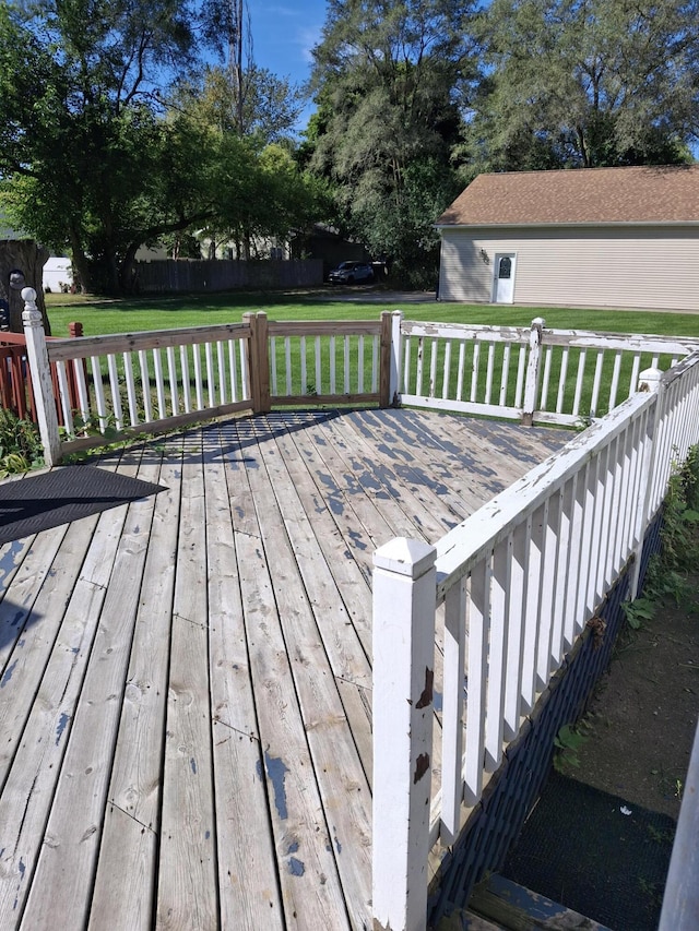 wooden deck featuring a lawn