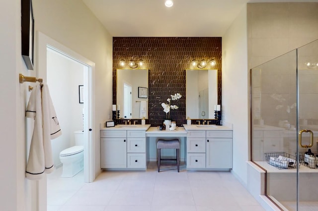 bathroom featuring tile patterned floors, vanity, a shower with shower door, and toilet