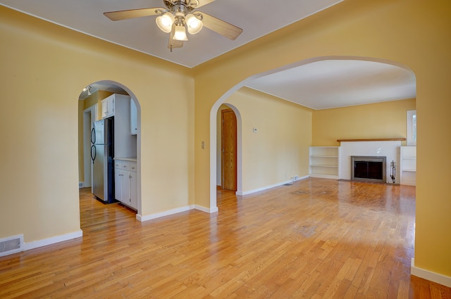 unfurnished living room featuring ceiling fan and light hardwood / wood-style floors