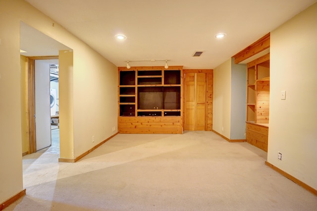 unfurnished living room featuring carpet flooring and track lighting