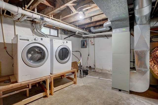 laundry room with washing machine and dryer, electric panel, and heating unit