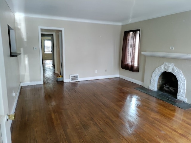 unfurnished living room with hardwood / wood-style floors and a tiled fireplace