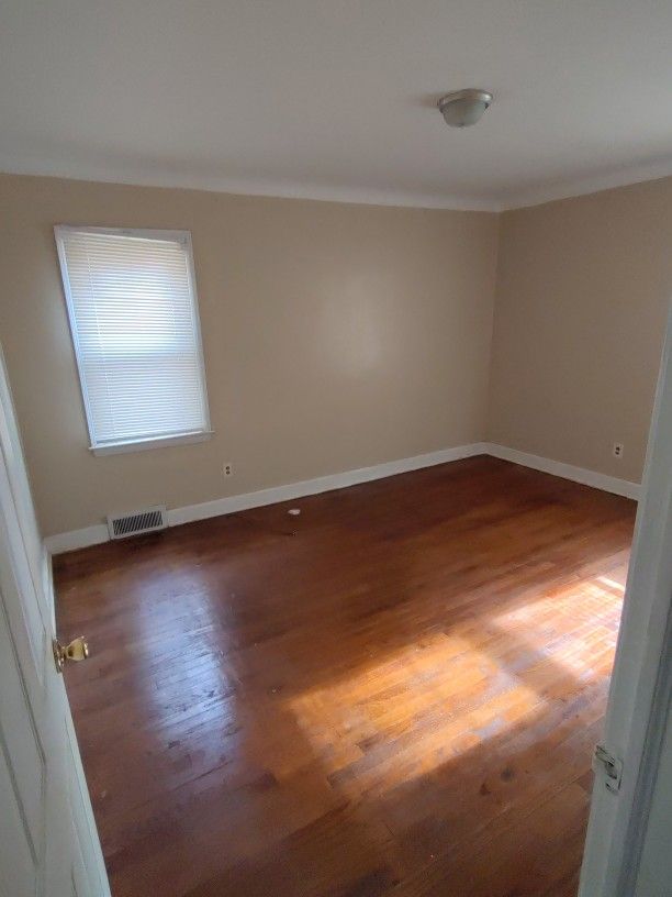 empty room with dark hardwood / wood-style flooring