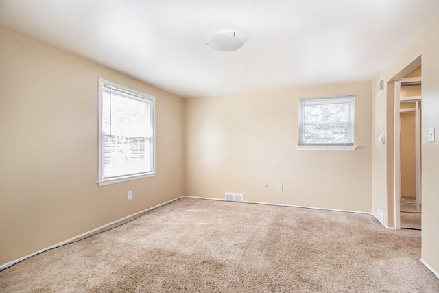 unfurnished room with carpet flooring and a wealth of natural light