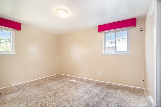 unfurnished room featuring a healthy amount of sunlight and carpet floors