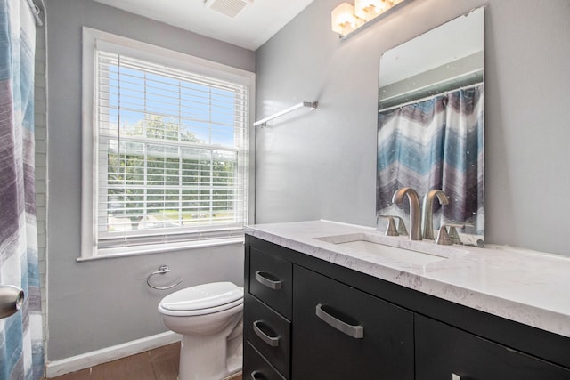 bathroom featuring vanity, toilet, and walk in shower