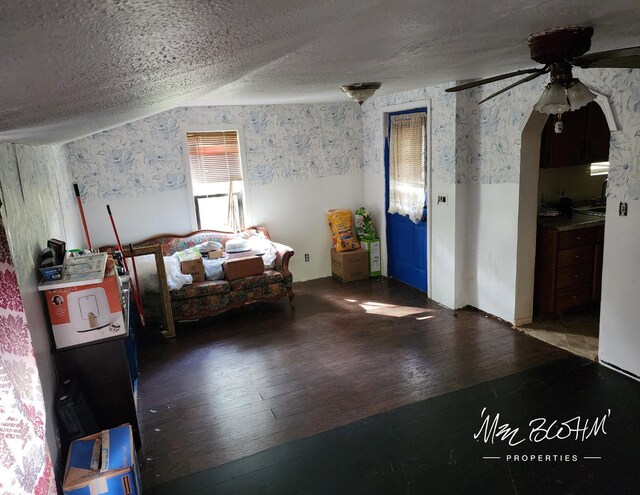 19136 130th Ave, Tustin, MI 49688 - bedroom featuring wood-type flooring, a textured ceiling, wallpapered walls, and arched walkways