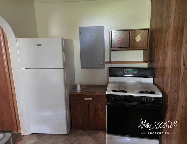19136 130th Ave, Tustin, MI 49688 - kitchen featuring freestanding refrigerator, range with gas cooktop, arched walkways, and stone finish floors