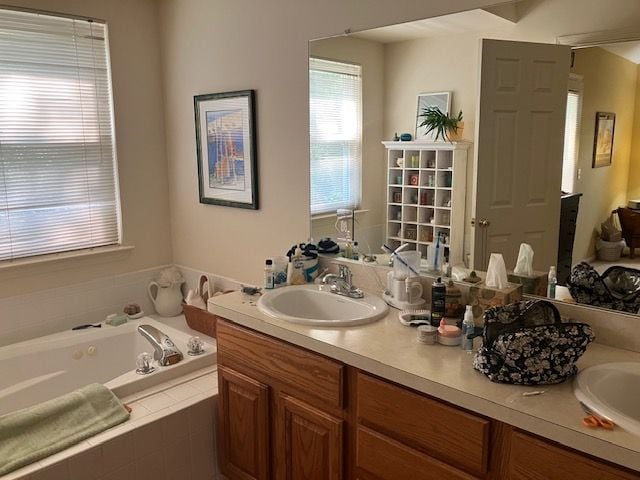 bathroom featuring vanity and tiled tub