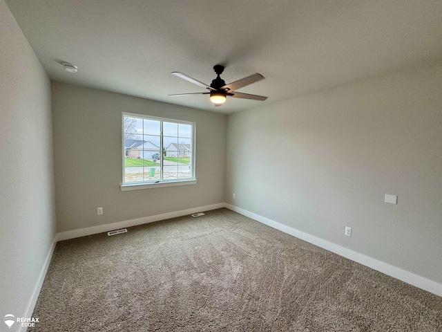 unfurnished room with ceiling fan and carpet