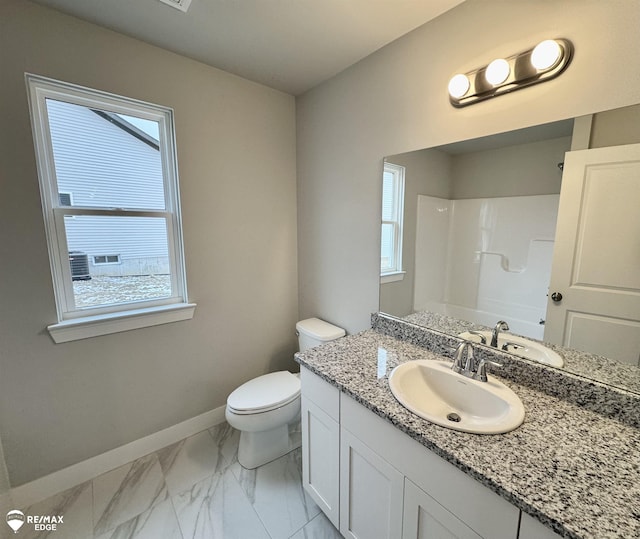 bathroom with vanity, a healthy amount of sunlight, and toilet