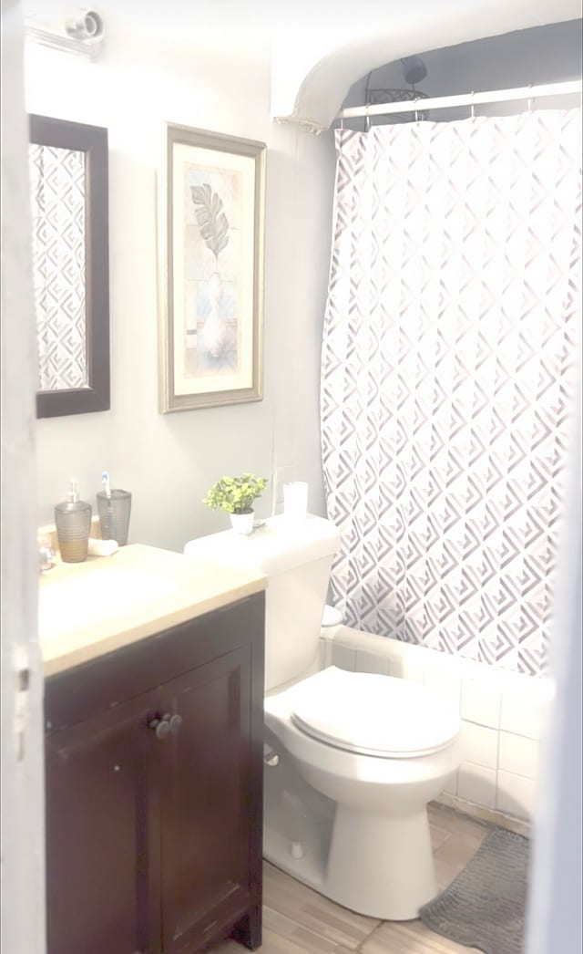 bathroom featuring curtained shower, vanity, tile walls, and toilet