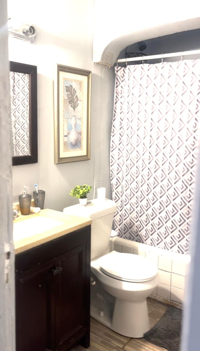 bathroom featuring a shower with curtain, vanity, and toilet