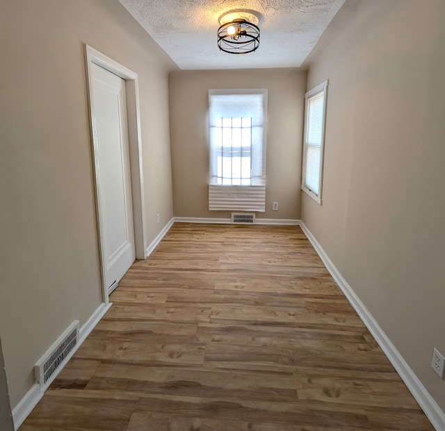 interior space featuring light hardwood / wood-style floors and a textured ceiling