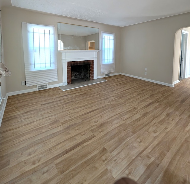 unfurnished living room with a fireplace and light hardwood / wood-style flooring