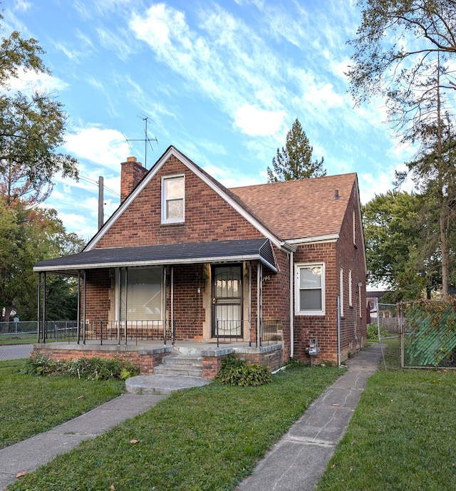 bungalow-style home with covered porch and a front yard