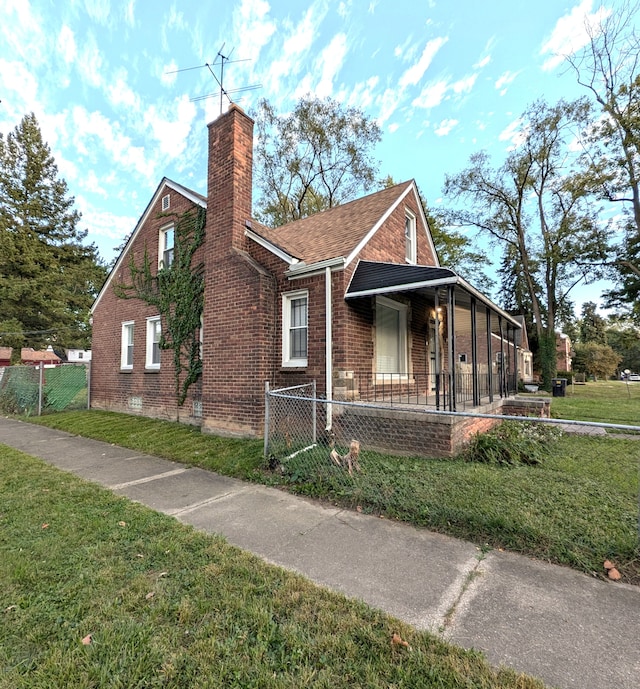 view of side of property with covered porch and a yard