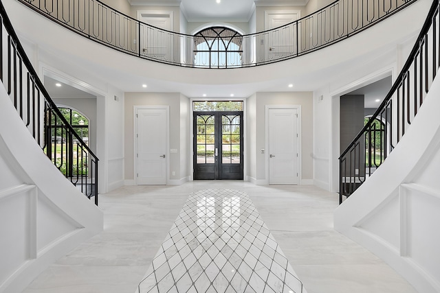 foyer featuring stairs, french doors, a towering ceiling, and baseboards