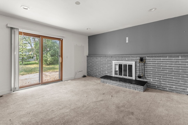 unfurnished living room with carpet and a fireplace