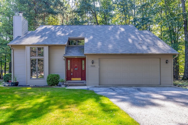 view of front of home with a front yard and a garage