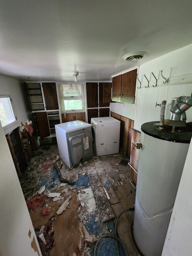 clothes washing area featuring a wealth of natural light, water heater, and washer / dryer