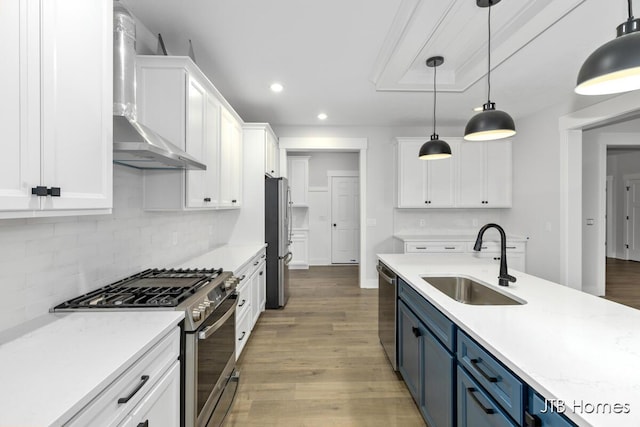 kitchen featuring blue cabinets, stainless steel appliances, decorative light fixtures, and white cabinets