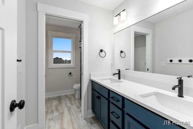 bathroom with vanity, hardwood / wood-style floors, and toilet