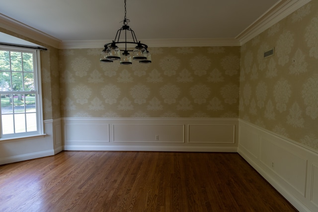 unfurnished dining area with dark hardwood / wood-style flooring, ornamental molding, and an inviting chandelier