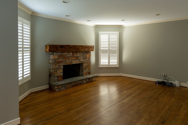 unfurnished living room with a stone fireplace, wood-type flooring, and ornamental molding