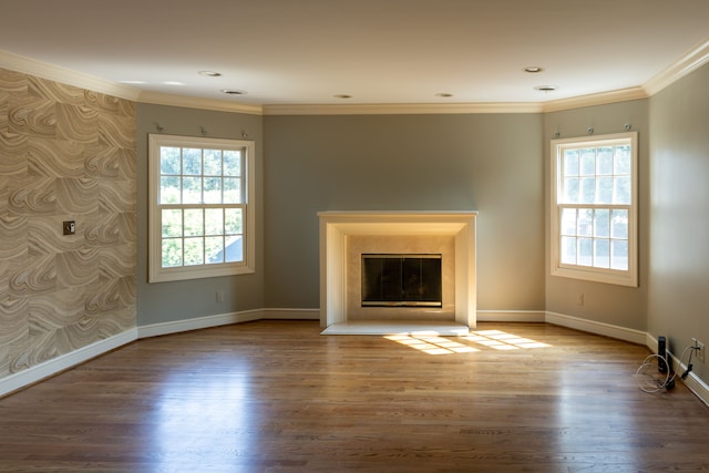 unfurnished living room with hardwood / wood-style floors, plenty of natural light, and crown molding