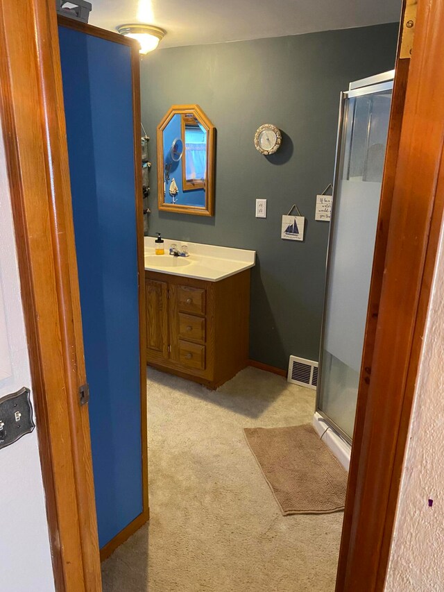 bathroom with vanity and a shower with door