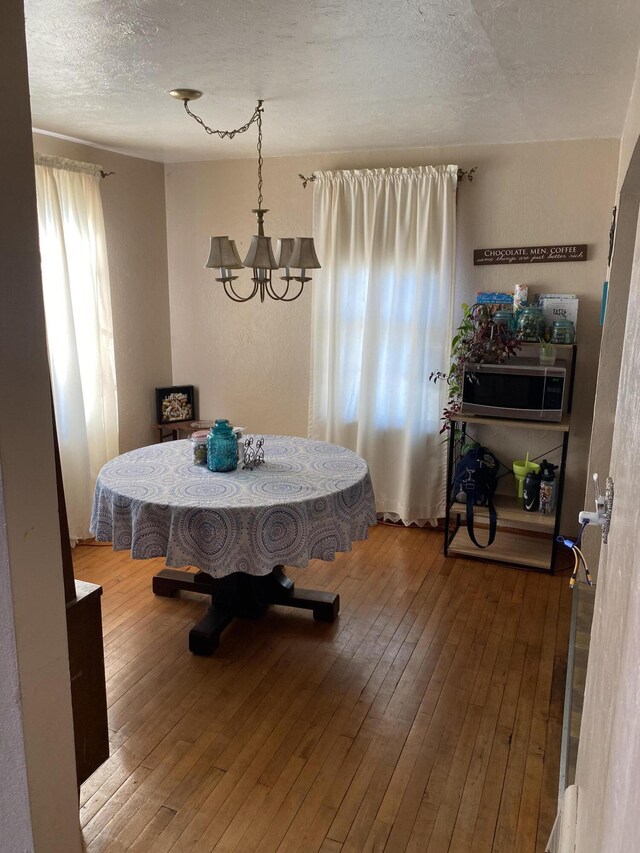 96 Harold St, Grant, MI 49327 - dining area with a chandelier, wood-type flooring, and a textured ceiling