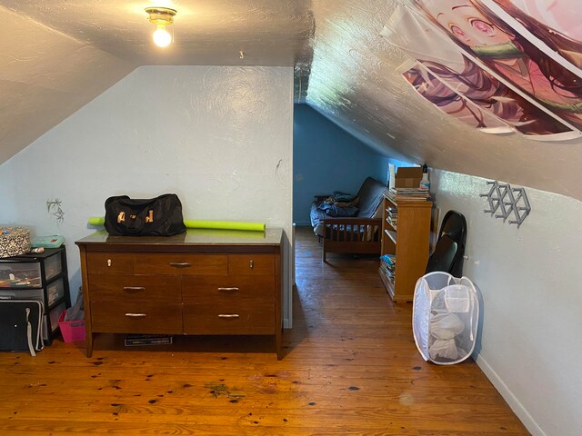 bonus room with lofted ceiling and dark hardwood / wood-style floors