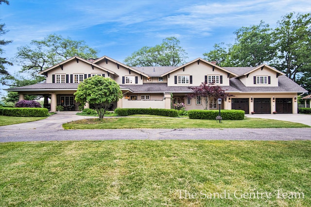 view of front of property featuring a garage and a front lawn