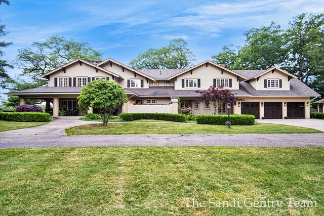 18635 N Fruitport Rd, Spring Lake, MI 49456 - view of front of house with curved driveway, stucco siding, a front lawn, and roof with shingles