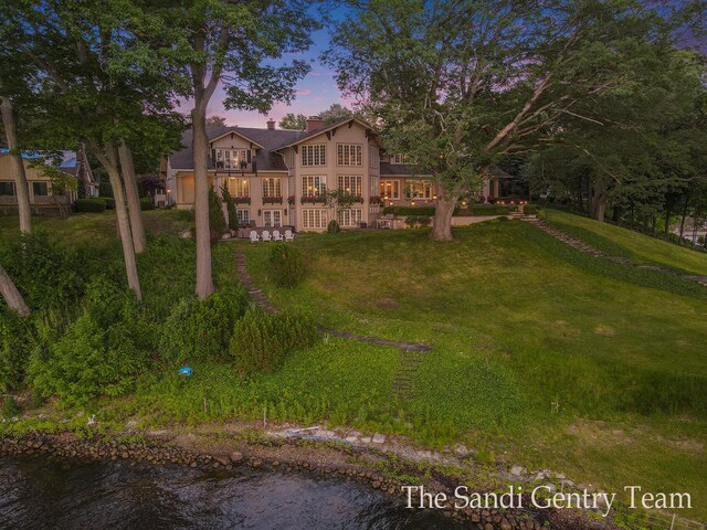 18635 N Fruitport Rd, Spring Lake, MI 49456 - view of front facade with a front yard, a chimney, a balcony, and stucco siding