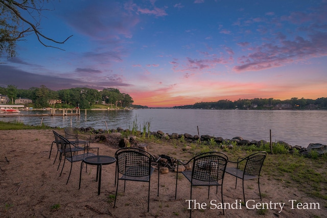 patio terrace at dusk featuring a water view